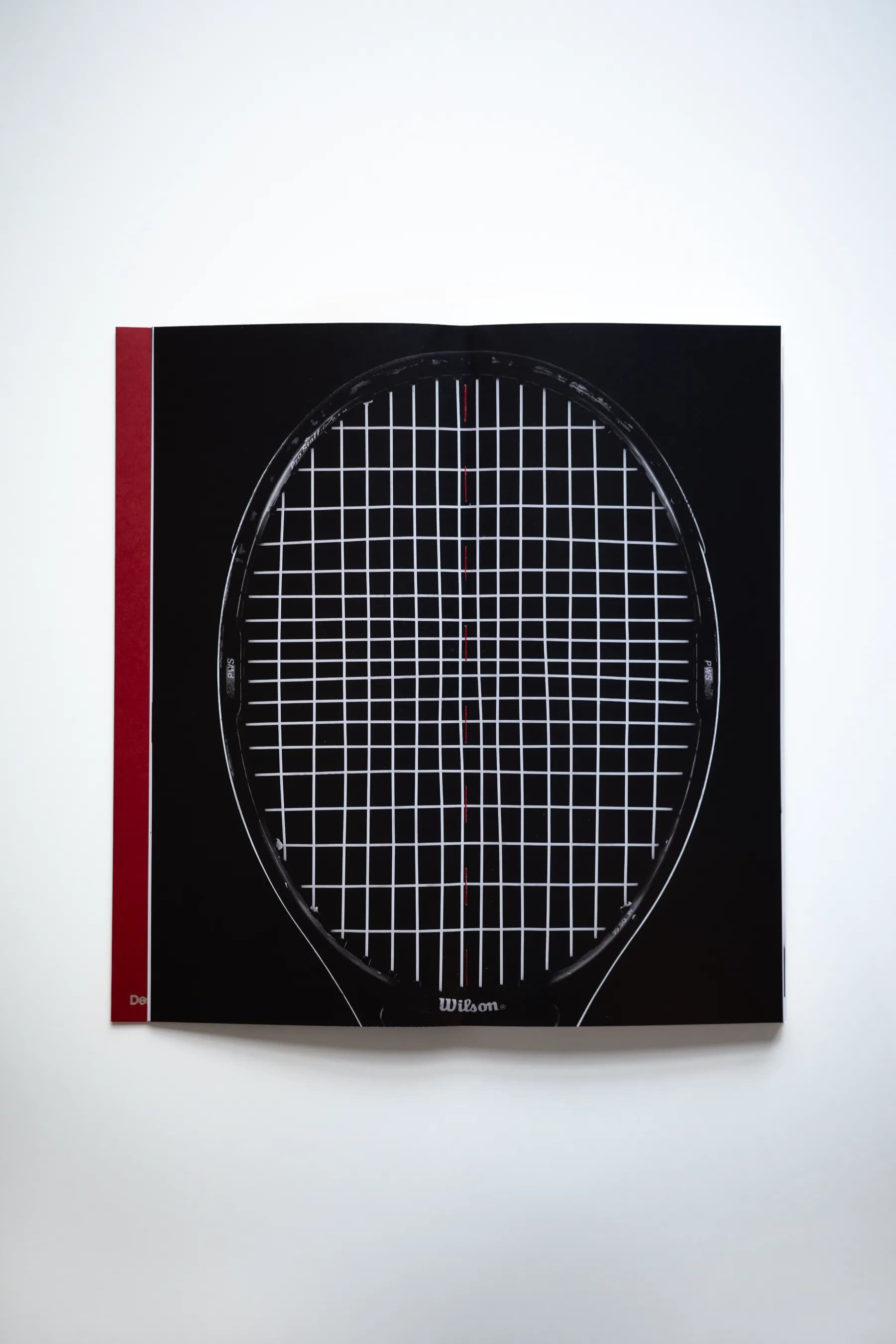 STRUNG: Issue 001 opened to a full-bleed black spread of a racket string bed photographed at actual scale